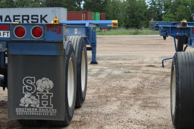 Red ocean container hooked to a Southern Haulers chassis, 2024